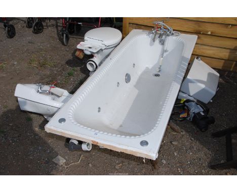 A white bathroom suite with jacuzzi bath and pump, basin, toilet etc.