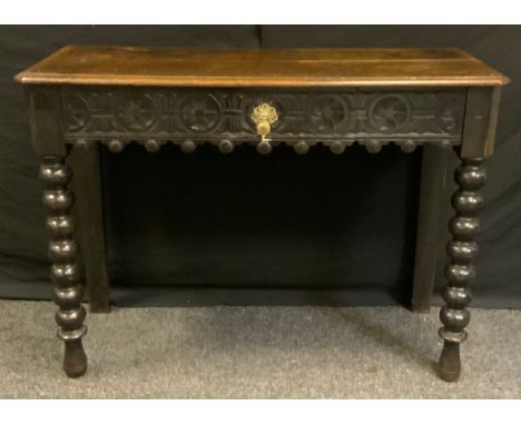 A 17th century style oak side table, rectangular top above a carved central short drawer, bobbin turned legs, 77cm hi8gh, 105