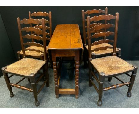 A set of four oak ladder back dining chairs, rush seats, turned legs; a 20th century oak drop-leaf table, bobbin turned legs.