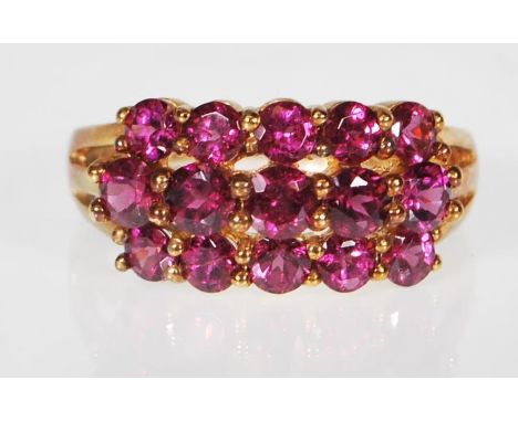 A 9ct gold (stamped 9k) Rhodolite garnet three row band dress ring, the ring set with 15 rhodolite cut stones.Size P weighing