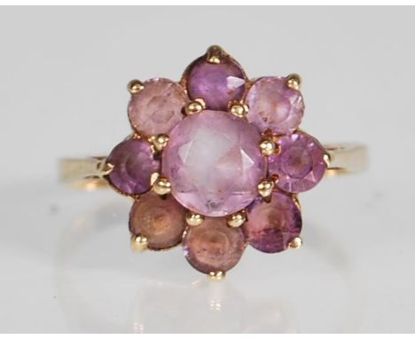 A 9ct yellow gold ring having a flower head mount set with round faceted cut amethyst. Marks rubbed. Gross weight 2.7g. Ring 