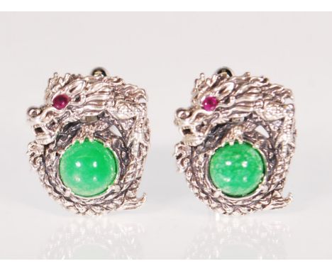 A pair of sterling silver Chinese dragon design cufflinks set with round jade cabochons set with red stone eyes. Weight 15.3g