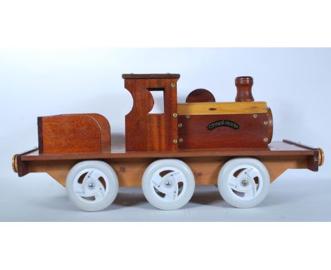A 20th Century scratch built sit on steam engine train. Constructed using various wood samples and then finished with a heavy