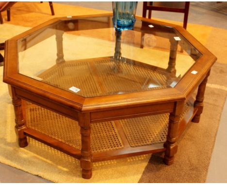 Octagonal mahogany glass topped coffee table with wicker under shelf