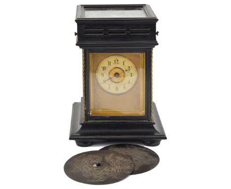 A Symphonion Clock:Ebonised square case on bun feet with twisted brass columns, the top lifting up to play 12cm disk, non pen
