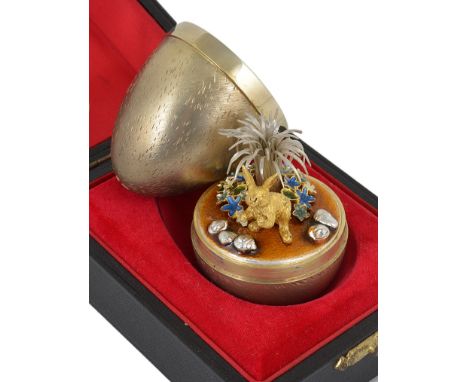 A Silver Gilt & Enamel Surprise Egg:By Stuart Devlin, London 1982, opening to reveal a rabbit in front of stylised frond.