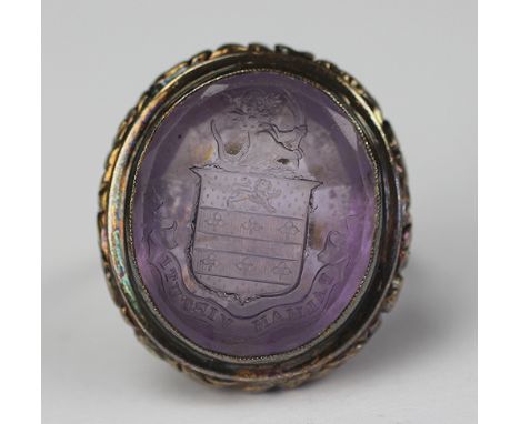 An amethyst intaglio set ring (converted from a seal) engraved family crest and motto 'Palmam Virtuti', within yellow metal s
