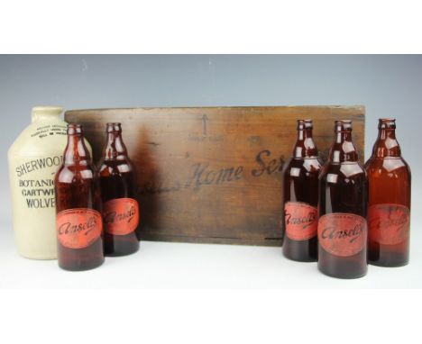 A vintage stained pine Ansells Home Service bottle rack, early 20th century, containing six Ansells bottles, 25cm H x 57cm W,