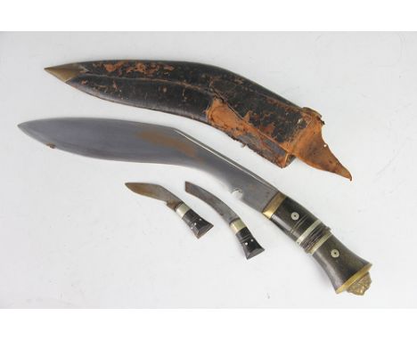 A Gurkha Kukri knife, with 28.5cm blade, horn handle with lion pommel, in scabbard with two other small knives