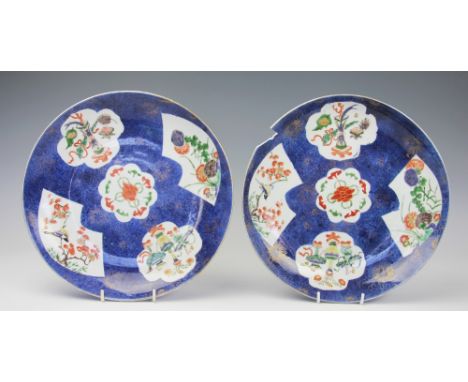 A pair of Chinese porcelain plates, Kangxi, (1662-1722), each decorated with panels in famille verte enamels against a powder