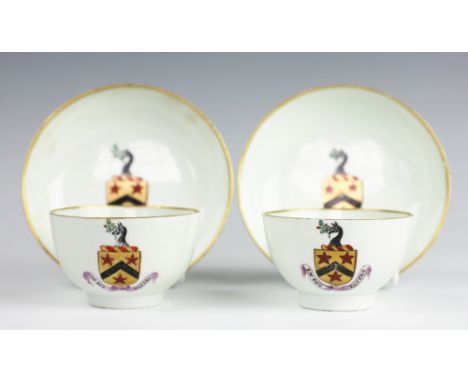 A pair of Lowestoft armorial porcelain tea bowls and saucers, circa 1790, painted in gilt with a coat of arms above a banner 