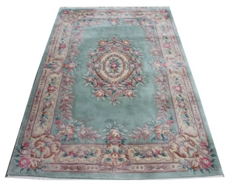 A modern Chinese wool carpet, worked with a floral design against a pale blue / green ground, 288cm x 183cm