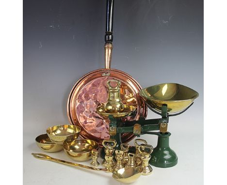 A set of green kitchen scales and brass weights, with a brass ladle and a copper warming pan etc 