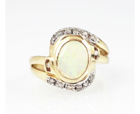 An opal and diamond set dress ring, the central oval opal within a cross-over diamond set surround, all set in yellow and whi