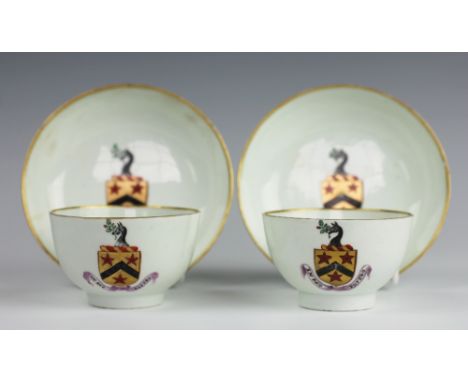 A pair of Lowestoft armorial porcelain tea bowls and saucers, circa 1790, painted in gilt with a coat of arms above a banner 