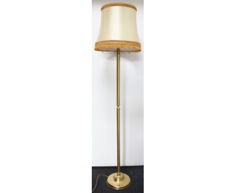 A brass standard lamp, on circular base, 135cm. Lighting lots are sold as decorative items only.  Prospective buyers must con