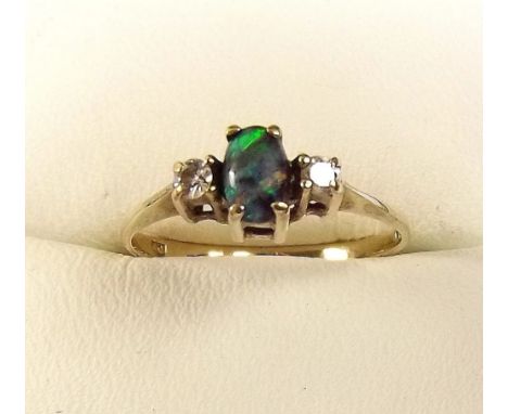 A 9ct gold ring set opal flanked by two diamonds 