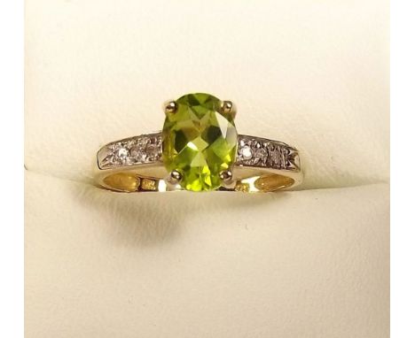 A 9ct gold peridot ring on diamond set shoulders 