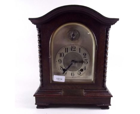 An arch top oak mantel clock with barley twist pilasters 
