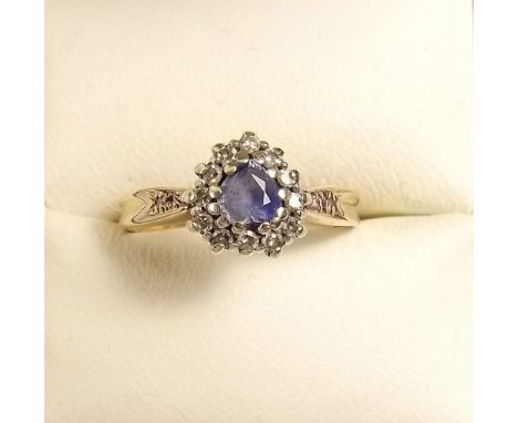 A gold ring with heart form cluster set blue stone and diamond surround