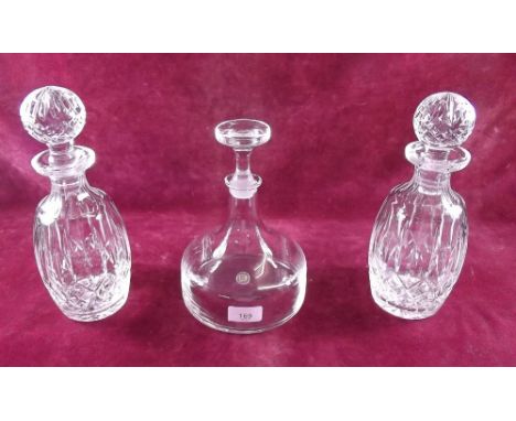 A pair of cut glass decanters and a Dartington decanter