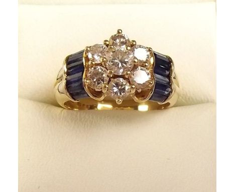 A diamond cluster ring on baguette cut sapphire shoulders