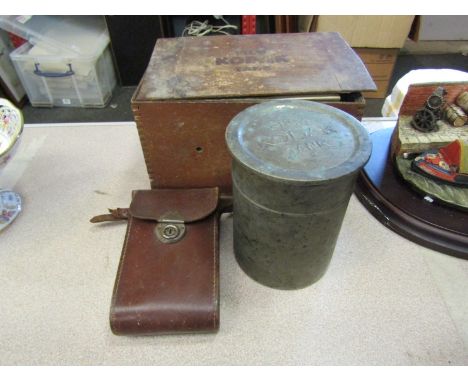 A Kodak box with various photographic accessories, a tin and a leather cased camera