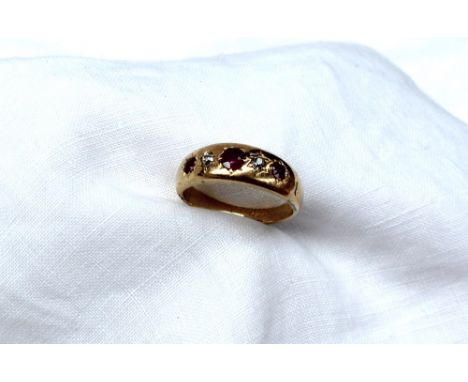 A yellow metal gypsy ring set with three rubies and two old cut diamonds, marked 18ct, approximately 3.6 grams
