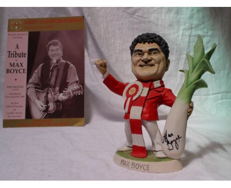 A Richard Hughes resin grogg of Max Boyce, the figure wearing a rosette with the Prince of Wales feathers and holding a leek,