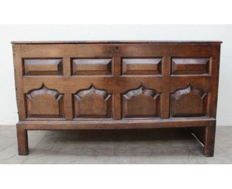 An 18th century oak coffer the planked rectangular top above an eight panel front on stiles, 144cm wide x 60cm deep x 83cm hi