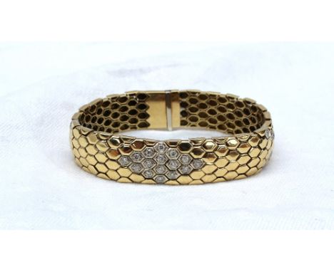 An 18ct yellow gold and diamond set bracelet of snake skin effect, set with thirty brilliant cut diamonds, marked 750, approx