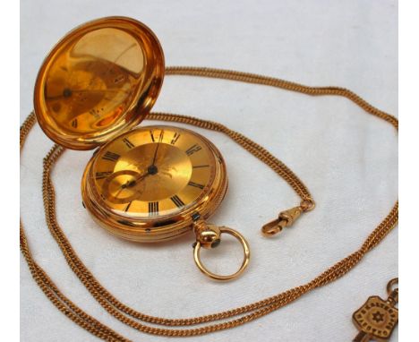 A Victorian 18ct yellow gold hunter pocket watch, with an engine turned outer case, the gilt dial with floral engraved centre