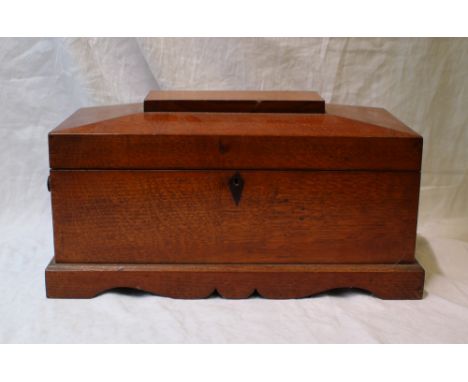 A 19th century oak tea caddy, of rectangular form with a domed hinged top enclosing two lidded compartments and a central wel