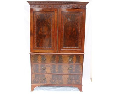 A late 19th century mahogany linen press, the moulded dentil cornice with a blind fretwork panel above a pair of cupboard doo