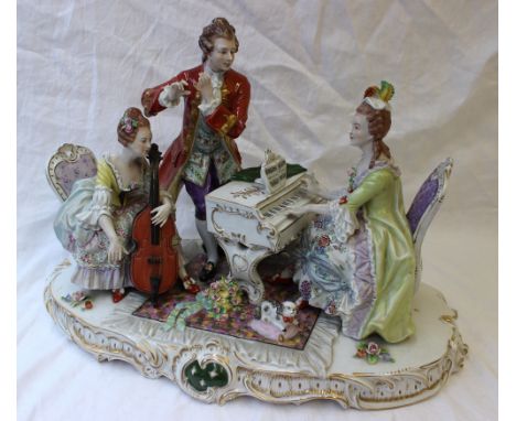 A large Capodimonte figure group depicting a musical trio, one playing a piano, the other a cello and the other a flute (flut