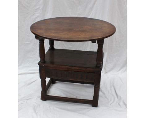 A 19th century oak Monks bench, the circular planked hinged top resting on the arm of the chair, with turned uprights, a plan