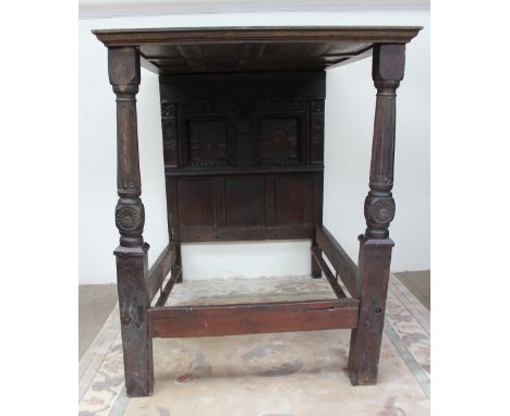A 17th century style three quarter oak four poster bed with a moulded cornice supported to the front by turned uprights, the 