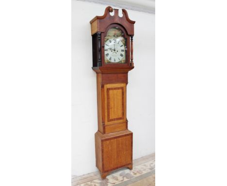 A 19th century oak longcase clock, the hood with a broken swan neck pediment and turned columns, above a short trunk door, bo