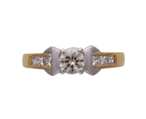 A diamond engagement ring in 18ct yellow and white gold, the central round cut diamond weighing approximately 0.46cts, flanke