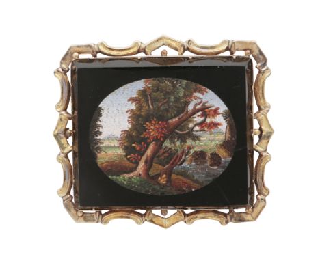 A fine antique micromosaic brooch depicting an oval landscape scene with trees and hills, within a black surround and in a gi
