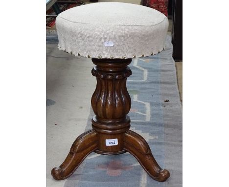 A Victorian mahogany revolving piano stool on tripod legs 