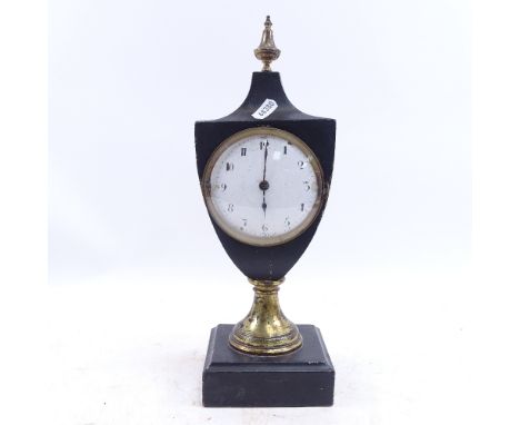 A mantel clock in ebonised case, with enamel dial, on brass support with Greek Key decoration and wooden plinth, height 34cm 