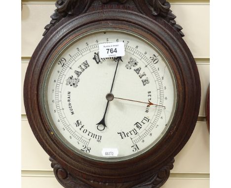 A carved oak-cased aneroid wall barometer and thermometer, ceramic dials, height 87cm 