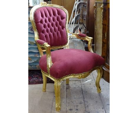 A giltwood button-back upholstered open arm chair 