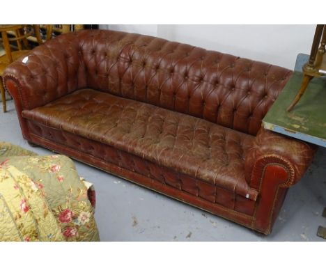 A red button-back leather upholstered Chesterfield settee 
