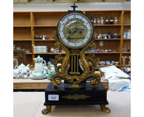 An ebonised and gilded mantel clock, with lion paw feet and Cupid design dial, height 40cm 