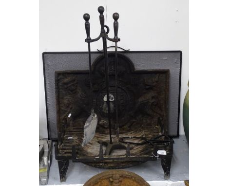 An 18th century embossed cast-iron arch-top fire back, with heraldic decoration, a duck's nest fire grate, companion tools et