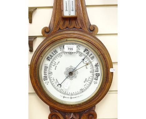 A carved oak-cased aneroid wall barometer, with ceramic dials, height 88cm 