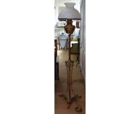 A late Victorian brass standard oil lamp, converted to electricity, with brass paw feet, and opening glass shade 