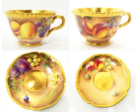 Pair of late 20th century Royal Worcester porcelain cups and saucers, shaped gilt rims and handles, fruit decorated with plum
